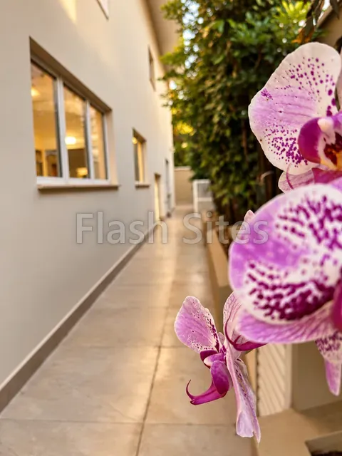 Corredor lateral com orquídeas, casa à venda no Condomínio Magnólias I em Araraquara